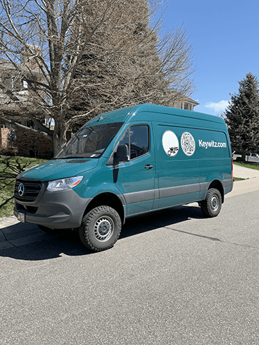 Art transportation services in Colorado featuring a Keywitz.com branded van on a residential street